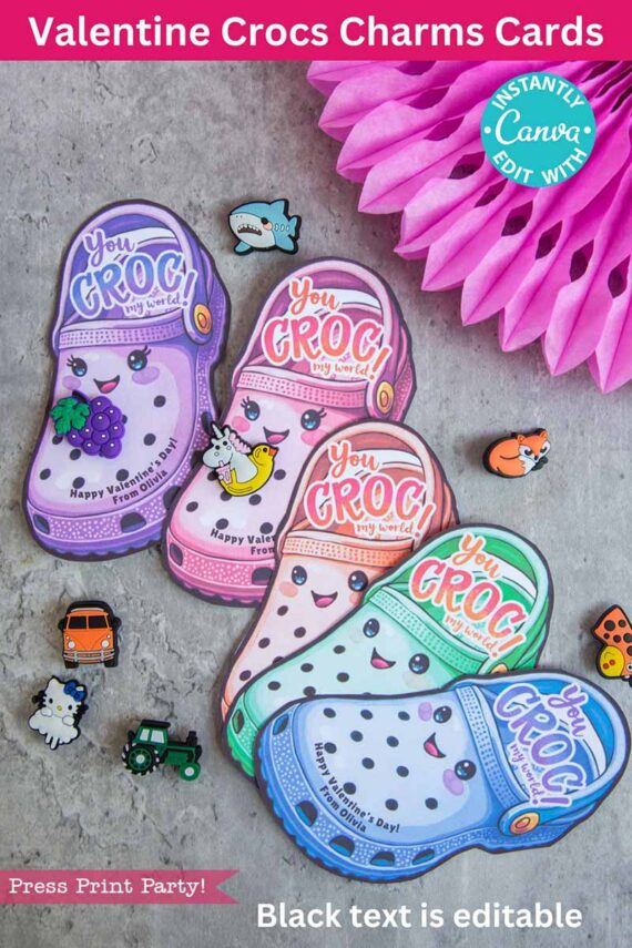 Valentine cards shaped like Crocs feature pastel hues and cartoon faces with the phrase "You CROG my world." Enclosed are whimsical charms such as a dog, dinosaur, and airplane. The header says, "Valentine Crocs Charms Cards.