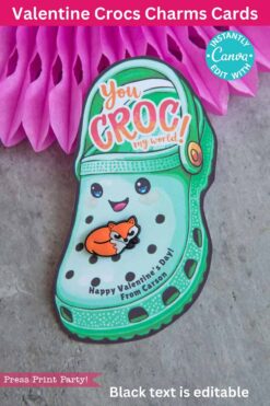 A Valentine card features a green crocodile-themed croc shoe with a smile. It reads 