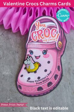 A Valentine card shaped like a pink Croc shoe, adorned with a unicorn pin on a yellow rubber duck. It reads 