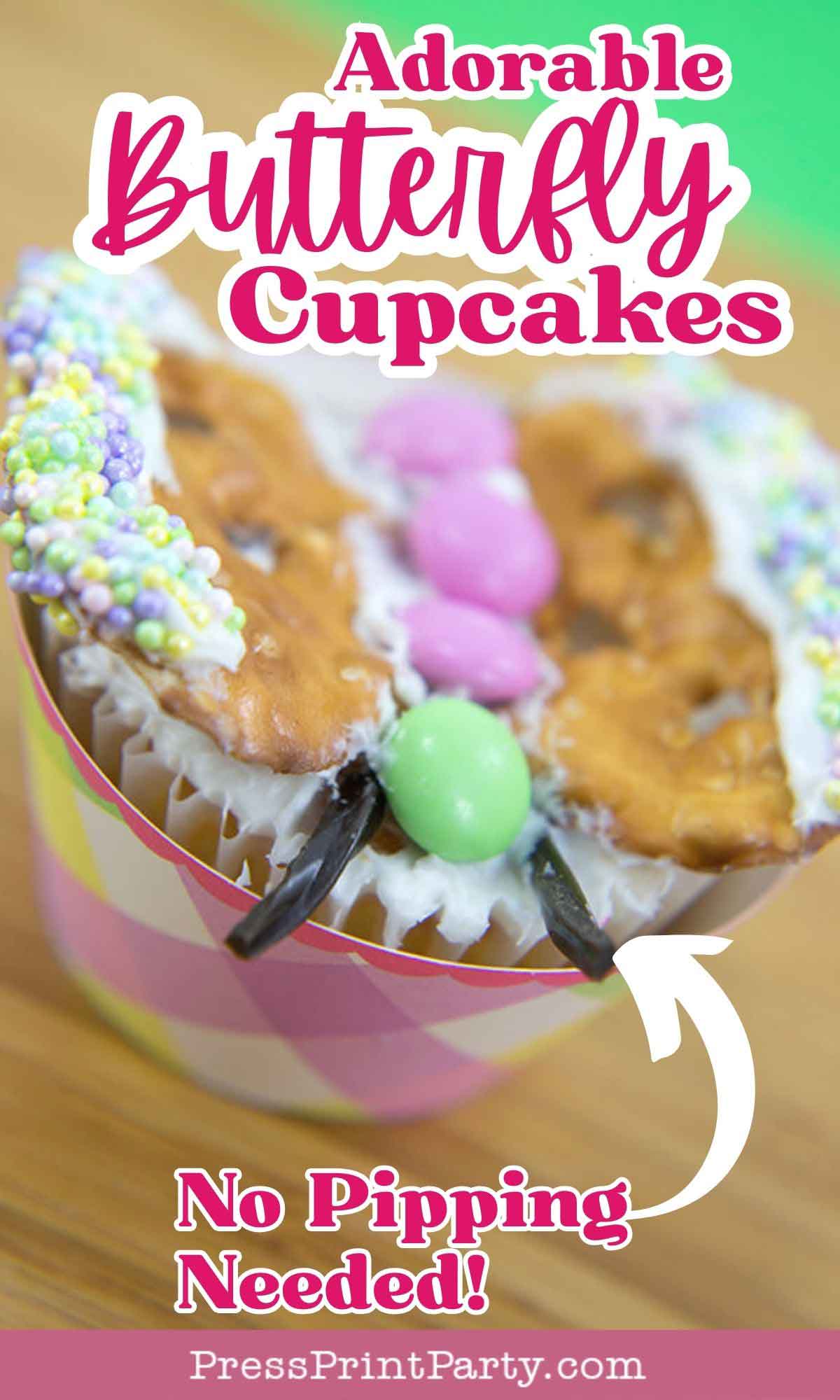 Colorful cupcake decorated with a butterfly theme. Pretzel wings are coated with white frosting and dotted with colorful sprinkles. Green and pink candies form the butterfly body. Text on the image reads "Adorable Butterfly Cupcakes" and "No Piping Needed!".