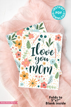 The Floral Mothers Day Card - Whimsy features "I love you MOM" with colorful flowers and leaves on pink fabric. Includes labels: "INSTANT PDF DOWNLOAD" and "Folds to 5” x 7”, Blank inside.