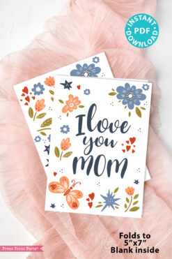 Two "Floral Mothers Day Card - Whimsy" designs with "I love you mom" in bold script, flowers, and a butterfly rest on pink fabric. Instant PDF download; each card folds to 5"x7" and is blank inside.