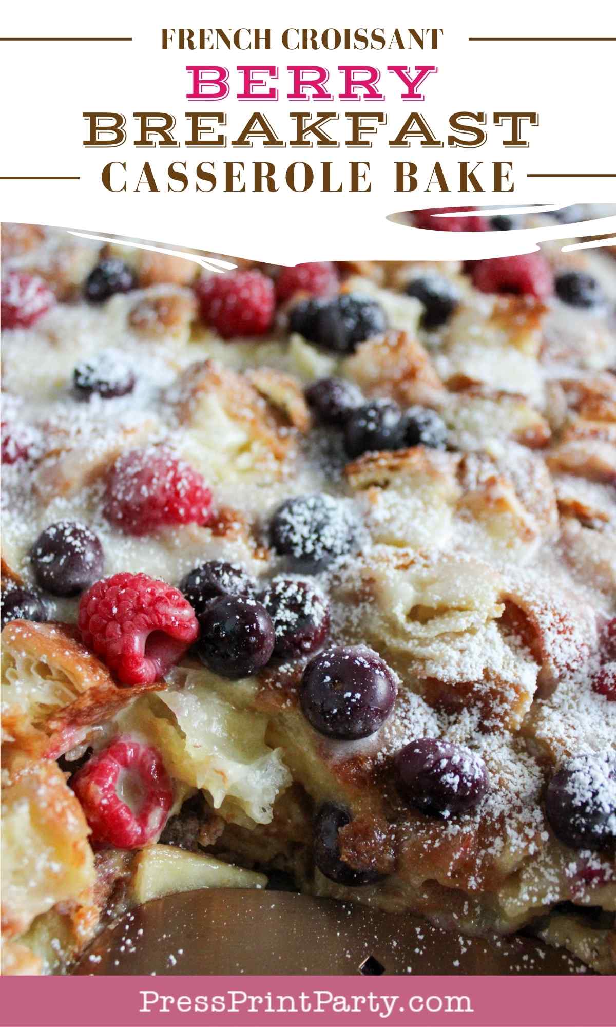Close-up of a baked berry croissant casserole topped with powdered sugar, raspberries, and blueberries, with text overlay reading "French Croissant Berry Breakfast Casserole Bake.