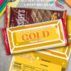 A flat lay of Thank You Chocolate Bar Wrap - Gold Bar covers on candy bars, surrounded by colorful stationery like paperclips, push pins, and sticky notes on a gray surface.