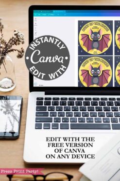 A laptop on a desk displays the Cute Ghost Halloween Gift Card Holder in Canva. Text overlay reads, โINSTANTLY EDIT WITH CANVA. Edit free on any device. Press Print Party!โ A plant and phone are nearby.