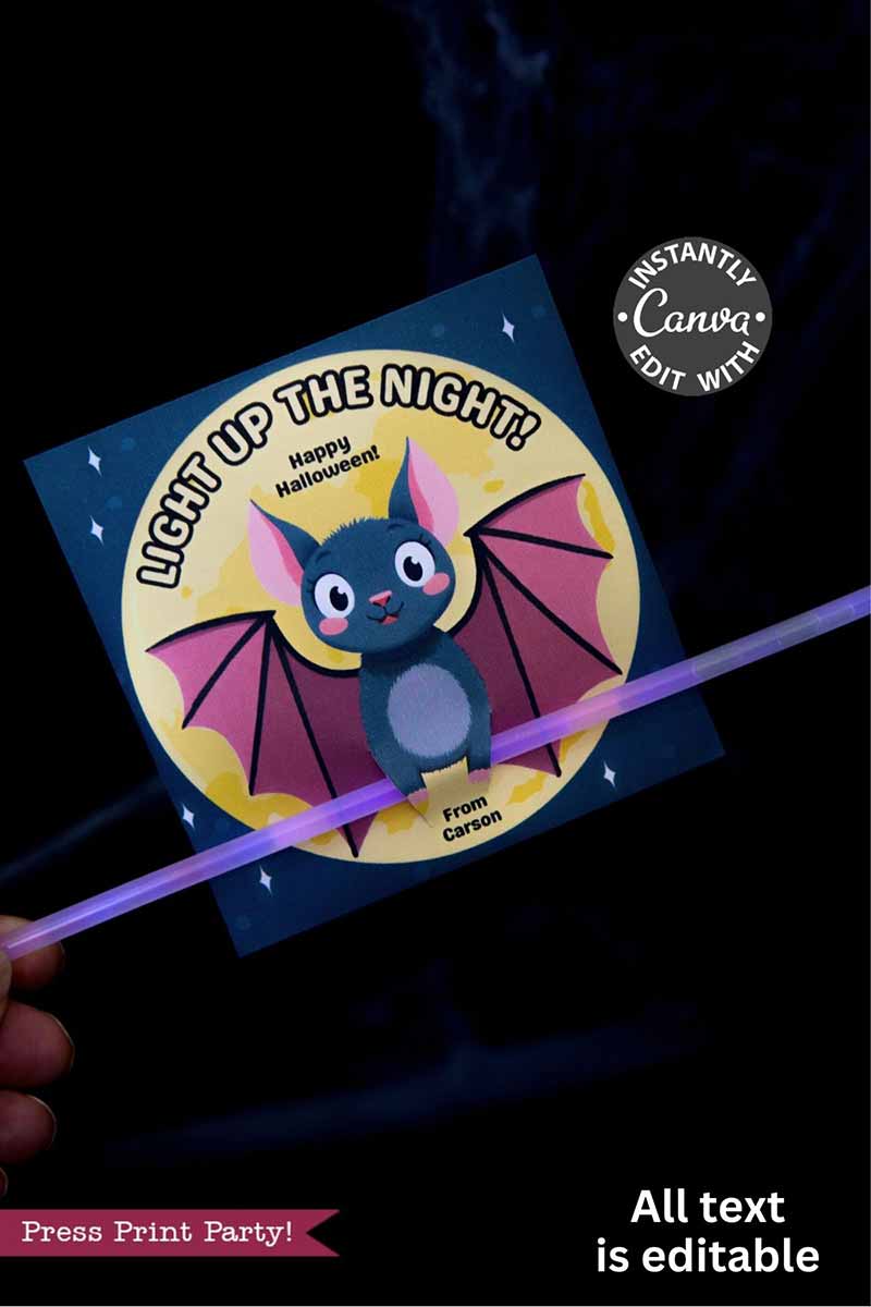 A hand holds the Cute Ghost Halloween Gift Card Holder featuring a cartoon bat, yellow moon, and editable text: "Light Up the Night! Happy Halloween! From Carson." This holder also has an attached glow stick; edit all text in Canva.