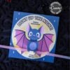 The Cute Ghost Halloween Gift Card Holder (Copy) is a square card with a cartoon bat, pink wings, stars, and "Light Up The Night! Happy Halloween." It holds a glow stick and gift card, and all text is editable. Perfect for Halloween gifting!.