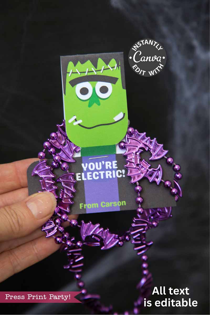 A hand holds the Cute Ghost Halloween Gift Card Holder featuring a cartoon Frankenstein's monster, “You’re Electric! From Carson” message, purple bat-shaped beads, editable text, and Canva customization options.