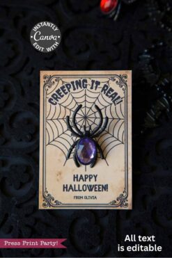 The Cute Ghost Halloween Gift Card Holder features a black background with ornate patterns and reads βCreeping It Real, Happy Halloween! From Olivia.β Includes a plastic black spider with a purple gem body.