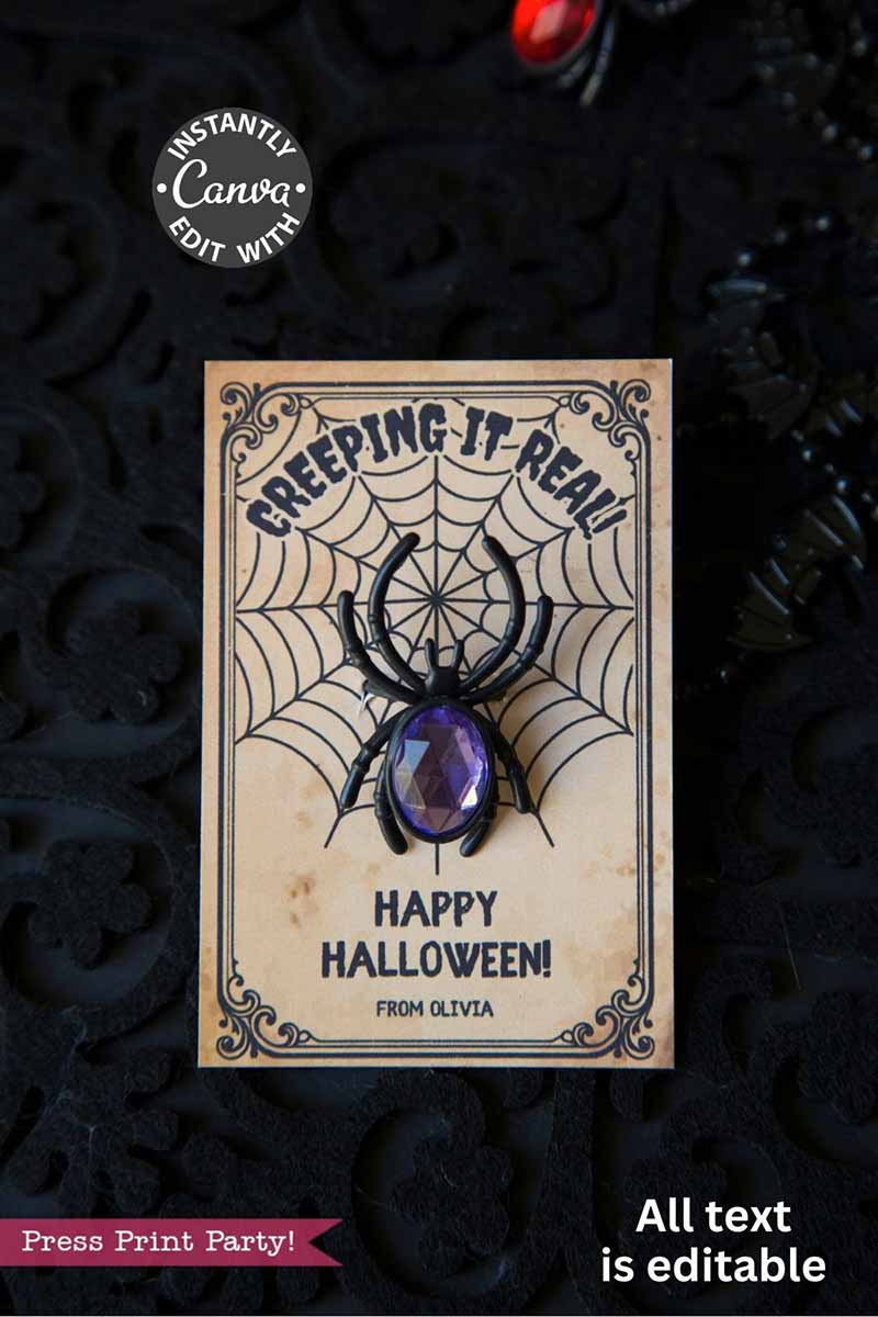The Cute Ghost Halloween Gift Card Holder features a black background with ornate patterns and reads βCreeping It Real, Happy Halloween! From Olivia.β Includes a plastic black spider with a purple gem body.