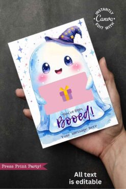 A hand holds the Cute Ghost Halloween Gift Card Holder, featuring a smiling ghost in a wizard hat, colorful stars, "You've been Booed!" text, space for a custom message, and a pink gift icon partially covering the card.