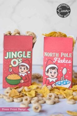 The Elf on the Shelf Breakfast Cereal Printable Kit features two festive cereal boxes with elves enjoying their bowls and cereals spilling out in front.