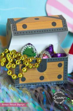 The Elf on the Shelf Mermaid Tail Printable Kit features a small paper treasure chest filled with colorful jeweled rings, gold bead necklaces, shiny purple wrappers, and displays a
