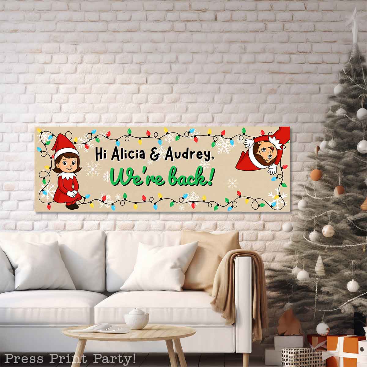 A festive living room with a white sofa and Christmas tree features a colorful banner on the wall that says, "Hi Alicia & Audrey, We're back!" with cartoon elves, lights, and holiday decorations. elf on the shelf im back sign. elf arrival ideas.