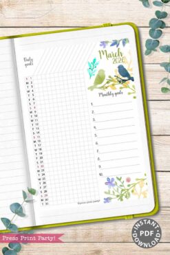 The 2026 Calendar Set & Habit Tracker, Watercolor Floral Design, is shown open to a March 2026 goals page with watercolor birds and flowers, daily and monthly goal lists, on a white wood surface with eucalyptus leaves and a pink βPress Print Party!β tag.