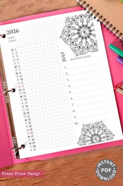 Part of the 2026 Calendar Set & Habit Tracker, this July page features a watercolor floral design, goals section, monthly goals list, and calendar grid. Shown on a pink surface with pens and a notebook nearby.