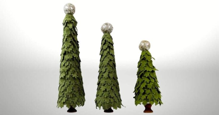 Three cone-shaped Christmas trees made of layered green leaves stand in a row, each topped with a shiny, silver, textured ball. The background is plain white.