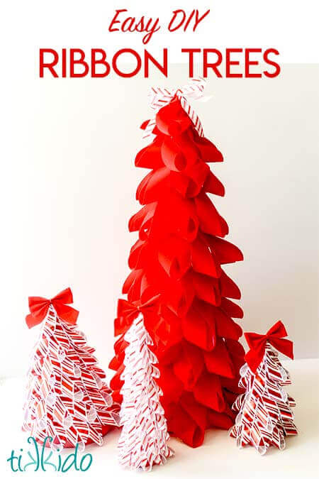 Four decorative Christmas trees made from red and white ribbon stand on a white surface. The largest tree is solid red, while the smaller ones feature white ribbons with red accents and red bows on top. Text reads “Easy DIY Ribbon Trees.”.