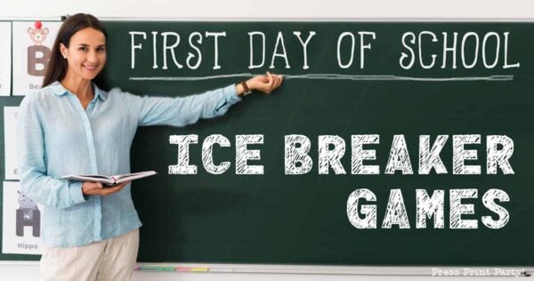 A teacher stands by a chalkboard pointing to the words "First Day of School Ice Breaker Games" in large letters. She holds an open book and smiles, ready to share fun ice breaker games for kids. Classroom posters with animals decorate the wall.
