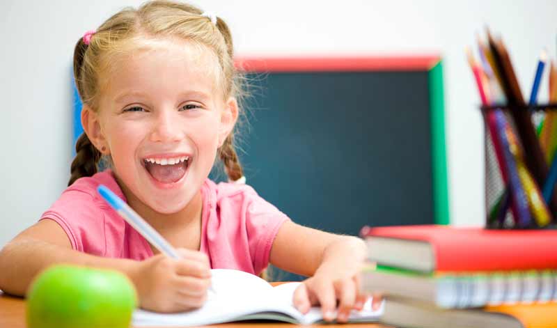 A girl smiling at the camera, ready to join in on fun ice breaker games for kids.