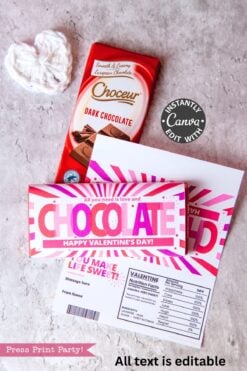 A Valentine’s Day chocolate bar with a pink and white wrapper sits on a card with custom text, next to the Valentines Day Socks Wrap Printable, another Choceur dark chocolate bar, and a crocheted heart.