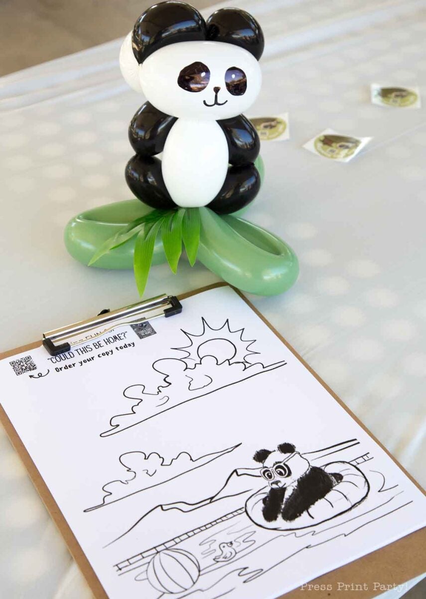 A balloon panda figure stands on a green base beside a clipboard with a panda coloring sheet, featuring a panda with balloons floating on water with mountains, sun, and beach ball in the background.