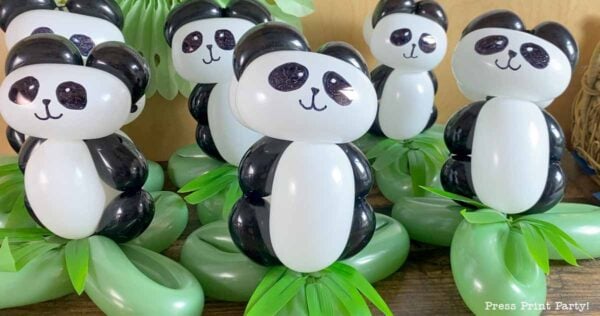Adorable panda with balloons sculptures are crafted from black and white balloons and arranged on green balloon bases resembling leaves. Each panda features drawn-on eyes, noses, and mouths for a charming finishing touch.
