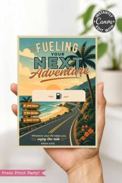 A hand holds the Gas Gift Card Holder Printable - Mountain, featuring a retro-style mountain scene and the text βFueling Your Next Adventureβ with checkboxes for βNew Roads,β βBig Dreams,β and βBright Future.β.