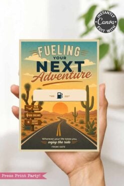 A hand holds the Gas Gift Card Holder Printable - Mountain, featuring a mountain scene and sunset. The card reads βFueling Your Next Adventure,β includes a fuel pump icon, blank space, and Kateβs note: βWherever your life takes you, enjoy the ride.β.
