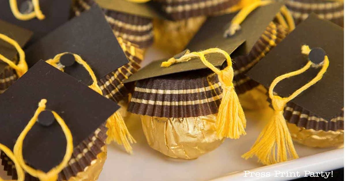 Gold-wrapped chocolates are decorated with brown paper graduation caps and yellow tassels, arranged closely together to resemble mini graduates.