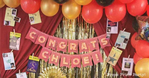 A festive theater themed graduation party backdrop with red and gold balloons, gold streamers, and a pink "CONGRATS CHLOE!" banner, surrounded by playbills from various musicals, celebrating a special occasion.