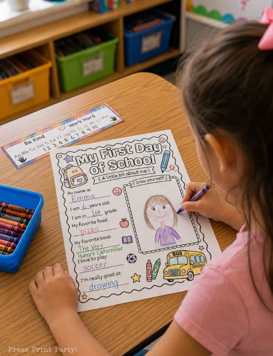 A young girl colors a “My First Day of School” worksheet at a desk with crayons. The worksheet includes personal info, her favorites, and a self-portrait space. Books and bins are on a shelf in the background.