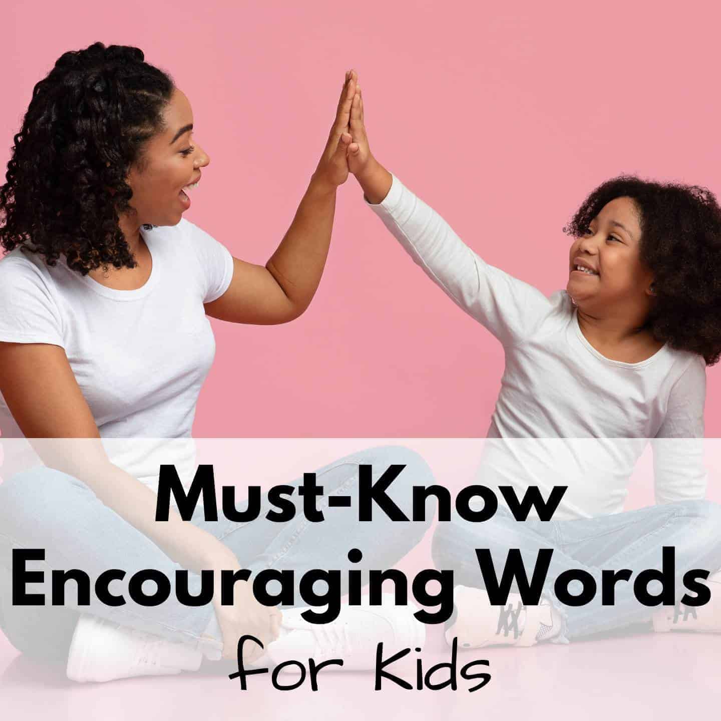 An adult and a child sit on the floor and high-five each other, both smiling. Text over the image reads, “Must-Know Encouraging Words for Kids.” The background is pink.