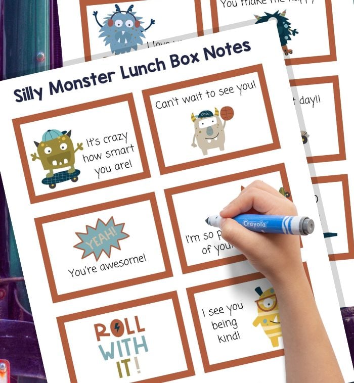 A child writes on a printed sheet titled “Silly Monster Lunch Box Notes” with cartoon monsters and encouraging messages like “You’re awesome!” and “Can’t wait to see you!”.