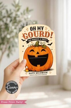 A hand holds a Halloween card featuring a smiling jack-o’-lantern, bats, and the text “Oh My Gourd! You deserve a treat! Happy Halloween!” on a light background—perfect for slipping into the 7 Vintage Halloween Gift Card Holders for an extra-special surprise.