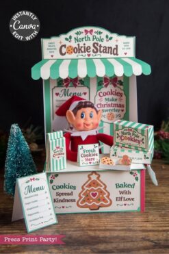 A festive “North Pole Cookie Stand” display featuring an elf doll, cookie signs, a holiday menu, and cheerful red, green, and white Christmas decor. Adorned with cookies and a gingerbread graphic, this charming setup becomes even more delightful when paired with the 6 Pink Coquette Halloween Ghost Round Labels for a whimsical touch to your holiday celebrations.