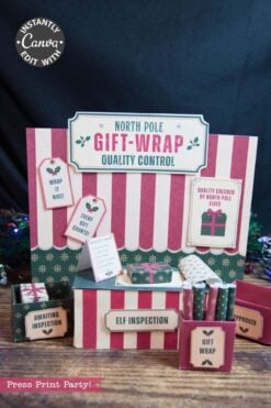 Striped holiday display featuring signs that say “North Pole Gift-Wrap Quality Control,” “Elf Inspection,” and “Awaiting Inspection,” with small gift-wrap items, checklists, and the 6 Pink Coquette Halloween Ghost Round Labels, creating a festive and whimsical workshop atmosphere.