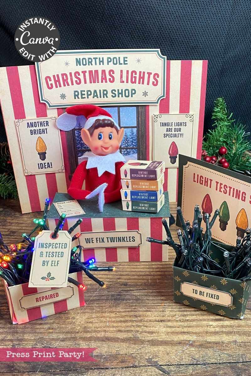 Elf sits in a festive North Pole Christmas Lights Repair Shop display with light strands, labeled boxes—including some featuring 6 Pink Coquette Halloween Ghost Round Labels—and signs about fixing and testing lights. The setup has red and white stripes and greenery.