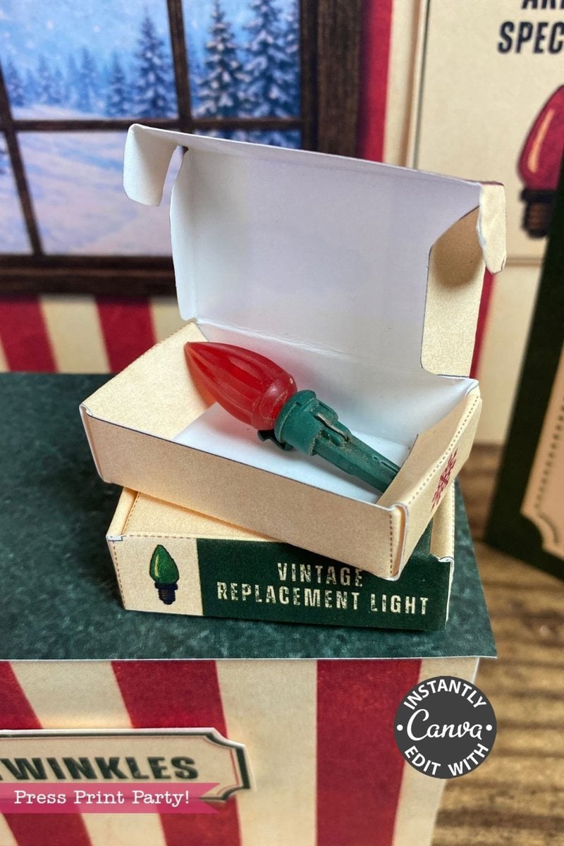 A red and green vintage replacement Christmas light bulb sits in an open cardboard box labeled “Vintage Replacement Light,” with holiday decor and a set of 6 Pink Coquette Halloween Ghost Round Labels adding a whimsical touch in the background.