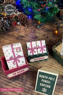 Christmas-themed paper boxes labeled “TO SCAN,” “CLEARED,” and “NORTH POLE PARCEL SORTING” are accented with 6 Pink Coquette Halloween Ghost Round Labels, and sit on a wooden table near a decorated Christmas tree and pinecones.