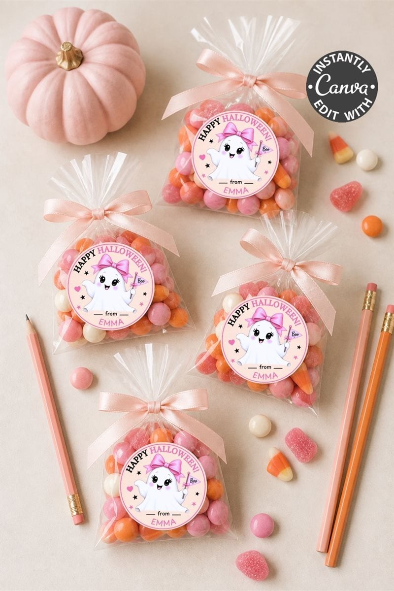Six bags of Halloween candies with adorable Pink Coquette Halloween Ghost Round Labels featuring cute unicorns, a small pink pumpkin, pink pencils, and scattered heart-shaped candies on a light surface.