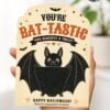 A hand holds a Halloween card featuring a smiling cartoon bat, stars, and bats with the message, “You’re BAT-TASTIC, you deserve a treat! Happy Halloween! Thanks for all you do from the Browns.” Perfect for slipping inside 7 Vintage Halloween Gift Card Holders to make your spooky surprise extra special.