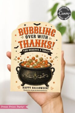 A hand holds one of the 7 Vintage Halloween Gift Card Holders, featuring a bubbling cauldron filled with colorful treats and the message, βBubbling over with thanks! You deserve a treat! Happy Halloween!β Decorated with black bats and festive stars, this card is perfect for presenting a gift card on Halloween.