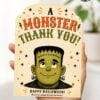 A hand holds one of the 7 Vintage Halloween Gift Card Holders, designed as a thank-you card featuring a cartoon Frankenstein’s monster with bolts in his neck and the greeting “A MONSTER THANK YOU!” above him. Surrounded by stars, lightning bolts, and festive colors, this playful holder is a perfect way to present any Halloween gift card.