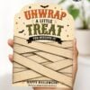 A hand holds one of the 7 Vintage Halloween Gift Card Holders, featuring a “UNWRAP A LITTLE TREAT YOU DESERVE IT!” message on a card wrapped in tan strips and decorated with stars and bats, making it perfect for creative Halloween gifting.