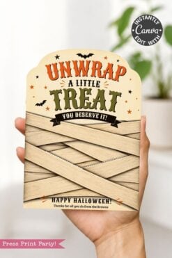 A hand holds one of the 7 Vintage Halloween Gift Card Holders, featuring a βUNWRAP A LITTLE TREAT YOU DESERVE IT!β message on a card wrapped in tan strips and decorated with stars and bats, making it perfect for creative Halloween gifting.