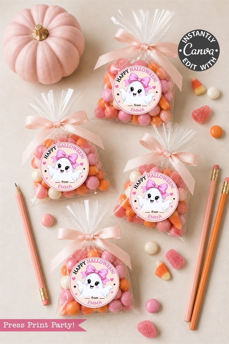 Four clear treat bags filled with pink, orange, and white candies are tied with ribbons and decorated with charming Pink Coquette Halloween Ghost Round Labels. Pink pencils, candy, and a small pumpkin are arranged on a light surface to complete this festive display.