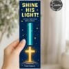 A hand holds a bookmark reading “SHINE HIS LIGHT! Let your light shine before others.” It features stars, a glowing cross, and “Matthew 5:16 From Calvin.” A circular label says “Instantly Canva Edit With.”.