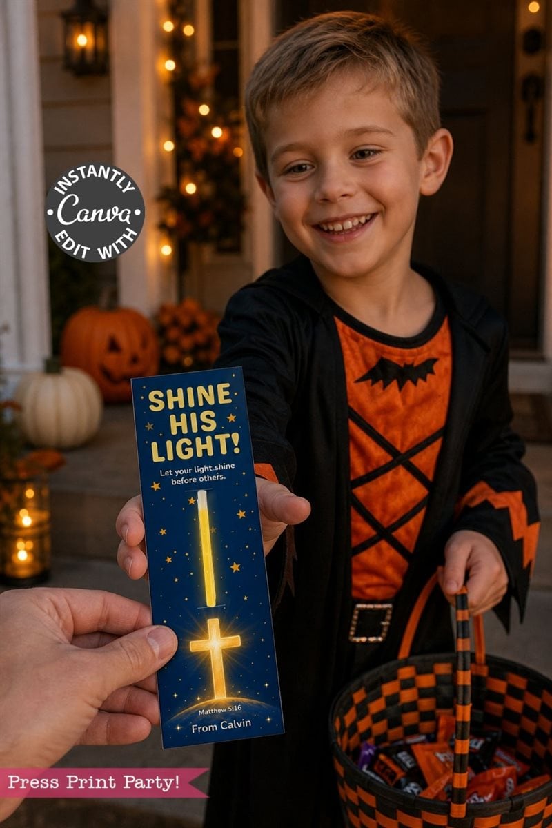 A smiling boy in a Halloween costume hands out a bookmark that says “SHINE HIS LIGHT” with a glowing cross. He holds a candy basket, and there are pumpkins and Halloween decorations in the background.