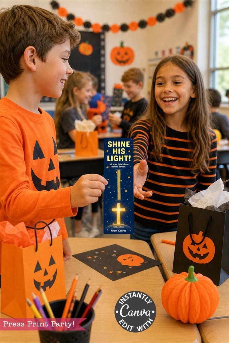Two kids in Halloween-themed attire smile and exchange a card that says “Shine His Light!” in a decorated classroom with pumpkin bags and party decorations.